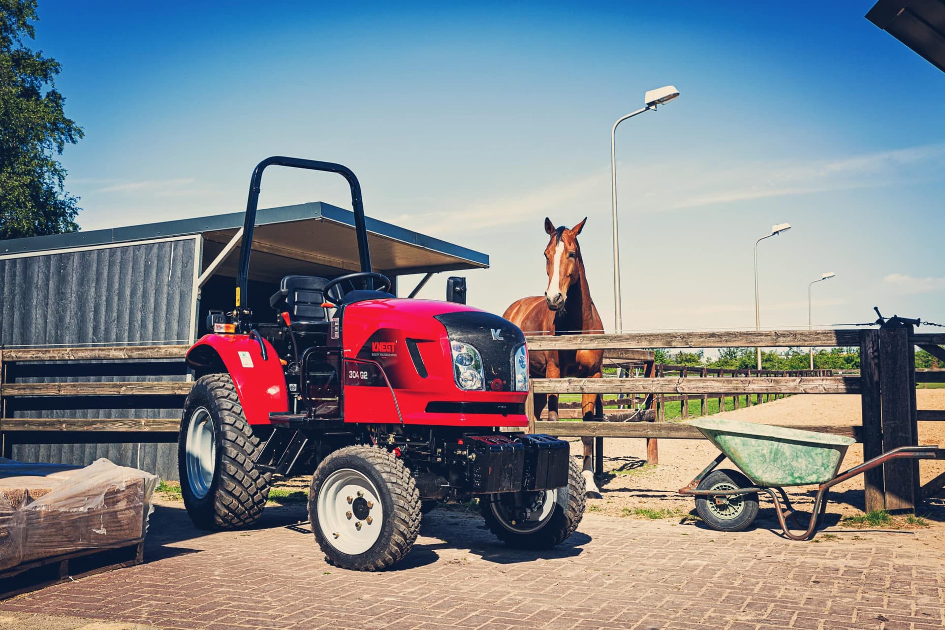 Dieseltractor bij stal met paard
